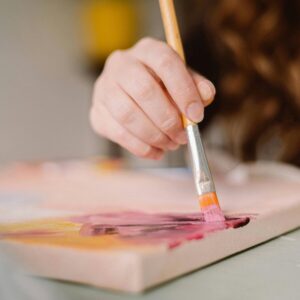 Hand die schildert met een penseel, voor de communitygroep Hobby's en fun