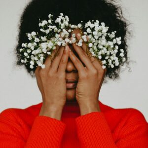 Vrouw met bloemen voor haar gezicht, voor de groep Mentale gezondheid