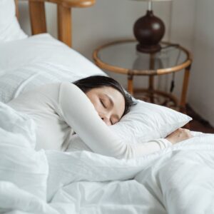 Vrouw die slaapt in een wit bed, voor de communitygroep Slaap